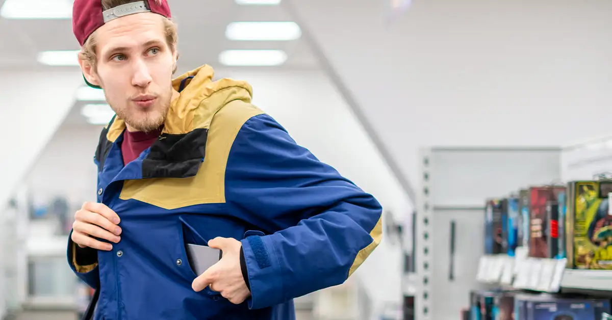 criminal thief stealing cell phone in the shop looking sideways